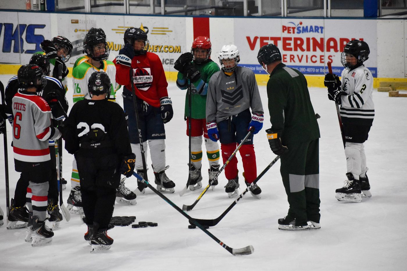 Campers gathered around a coach on the ice